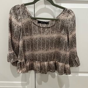 Cute cropped blouse with ruffle detail on sleeves and bottom.